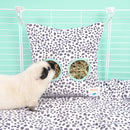 cochon d'inde blanc mange du foin depuis un haybag motif dalmatien de la marque kavee, dans une cage c&c kavee