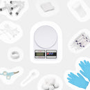 Les accessoires de la trousse à pharmacie Kavee : une balance, des seringues, des bandages, des gants, une cuillère, un coupe-ongles, des cotons tiges et du ruban adhésif.